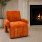 An orange textured armchair with a rounded, modern silhouette, positioned in a living room setting next to a lit fireplace and a potted plant.
